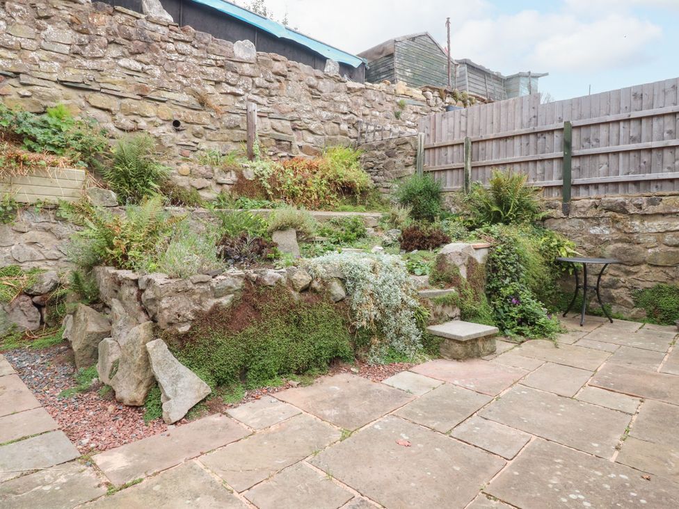 A garden with stone walls and steps at Cosy Bee in Heysham