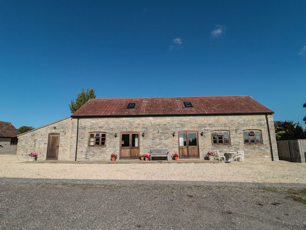 A stone building with a front door and windows at Bramble Cottage in Somerton