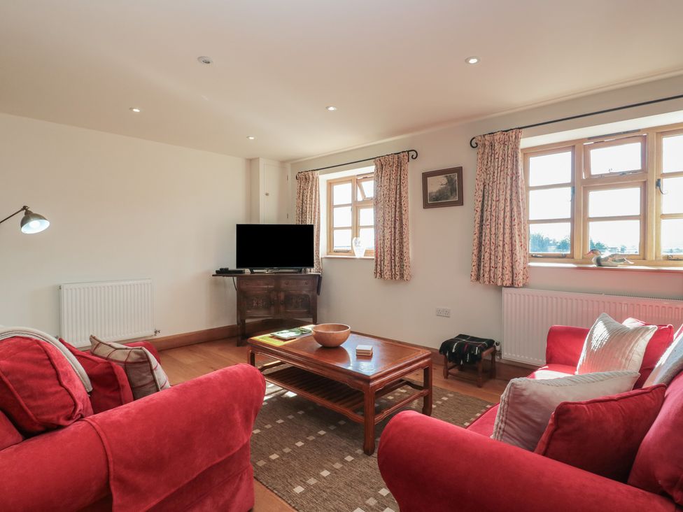 A living room with a sofa and television at Bramble Cottage in Somerton