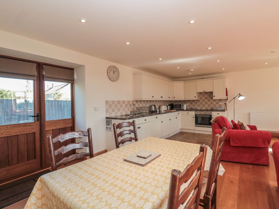 A kitchen with a dining table and appliances at Bramble Cottage in Somerton
