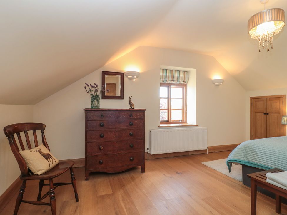 A bedroom with a chair and dresser at Bramble Cottage in Somerton