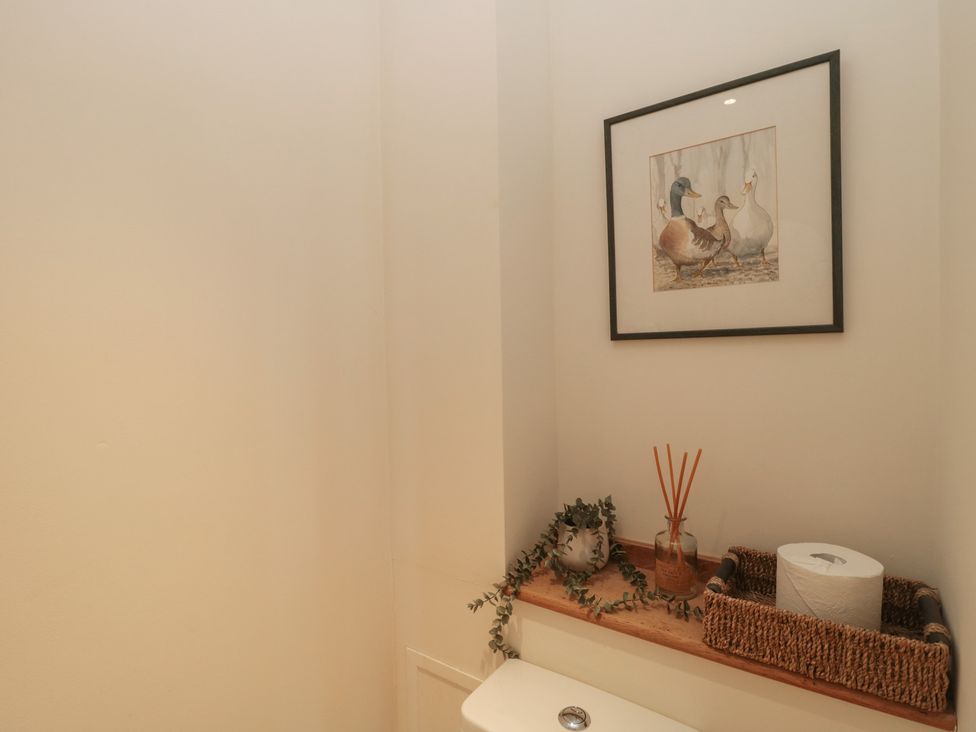 A bathroom with a toilet and decorative items at Bramble Cottage in Somerton