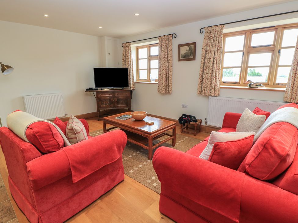 A living room with a sofa and television at Bramble Cottage in Babcary near Lydford-On-Fosse