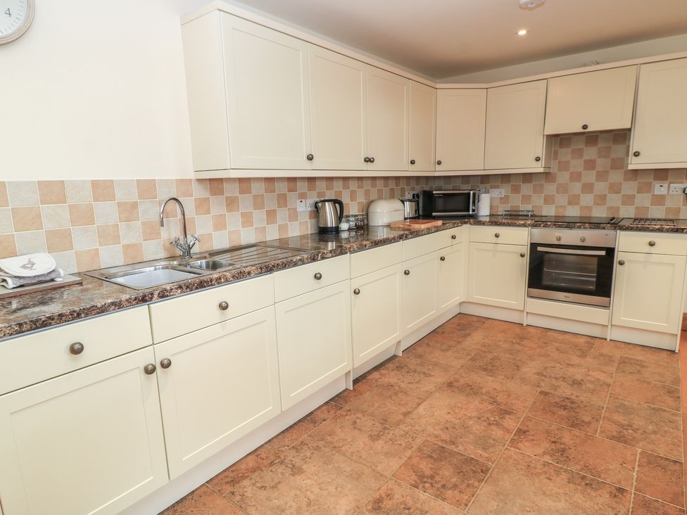 A kitchen with appliances and cabinets at Bramble Cottage in Babcary near Lydford-On-Fosse