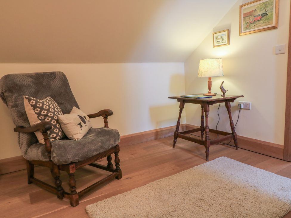 A nook with an armchair and side table at Bramble Cottage Babcary near Lydford-On-Fosse