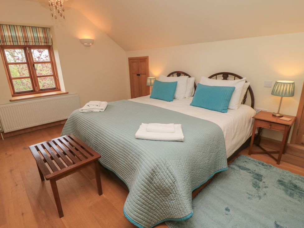 A bedroom with a double bed and bedside table at Bramble Cottage in Babcary near Lydford-On-Fosse