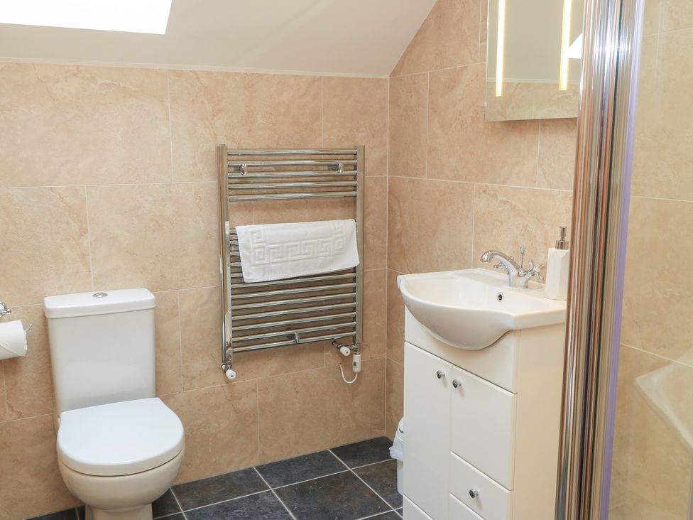 A bathroom with a toilet, sink, towel rack, and shower at Bramble Cottage in Babcary near Lydford-On-Fosse