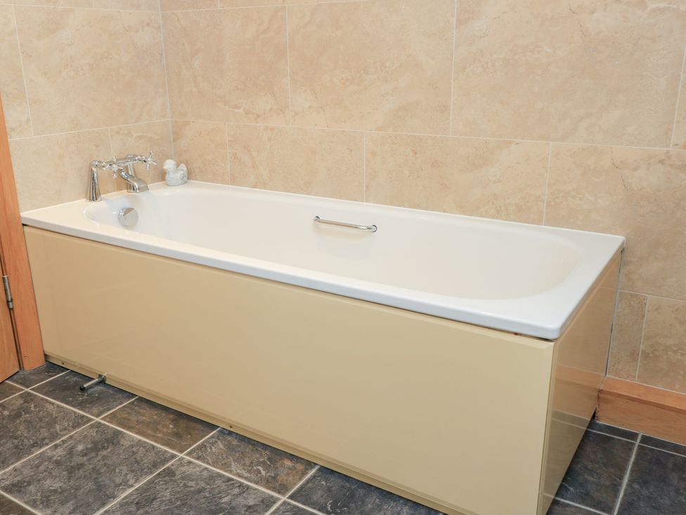 A bathtub with faucet in a bathroom at Bramble Cottage, Babcary near Lydford-On-Fosse
