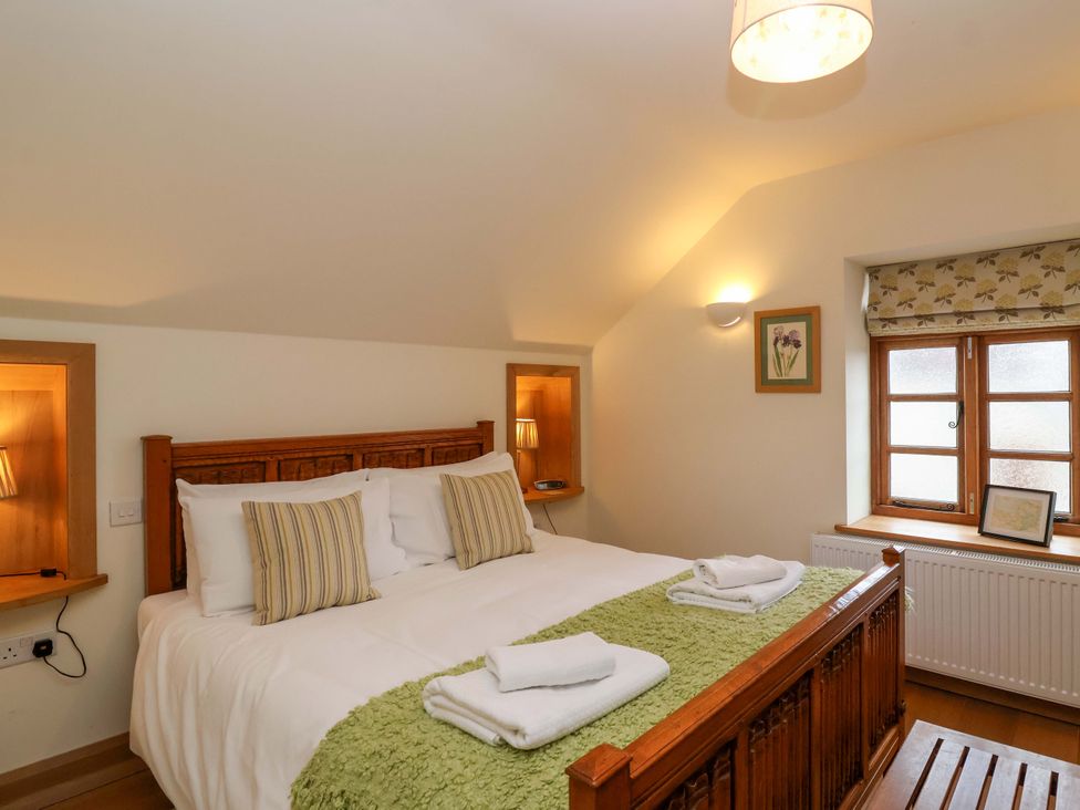A bedroom with a bed and window at Badger Cottage in Lydford-On-Fosse