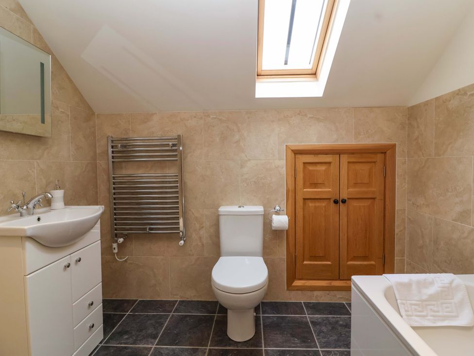 A bathroom with sink, toilet, and bathtub at Badger Cottage in Lydford-On-Fosse