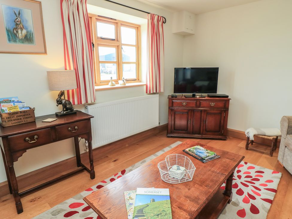A living room with a sofa and a television at Badger Cottage in Babcary near Lydford-On-Fosse