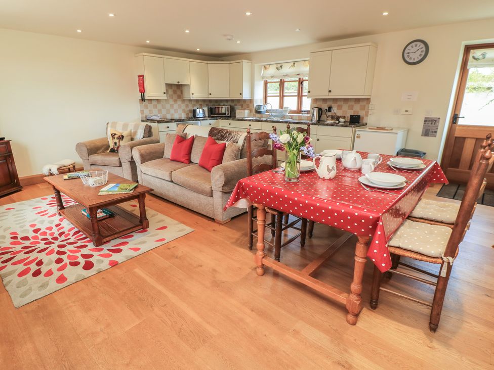 A living room with a sofa and dining table at Badger Cottage in Babcary near Lydford-On-Fosse