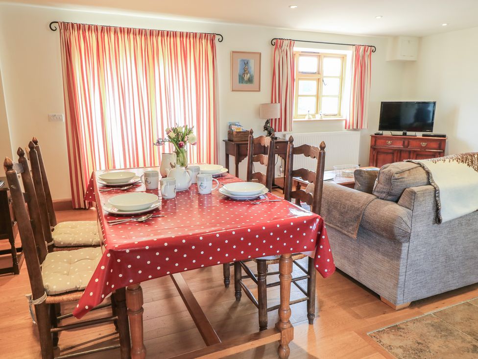 A dining room with a table set for meals at Badger Cottage in Babcary near Lydford-On-Fosse