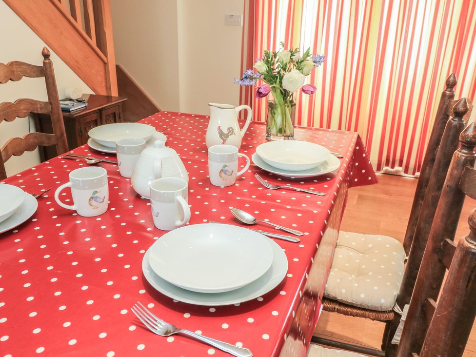 A dining table set with dishes at Badger Cottage in Babcary near Lydford-On-Fosse