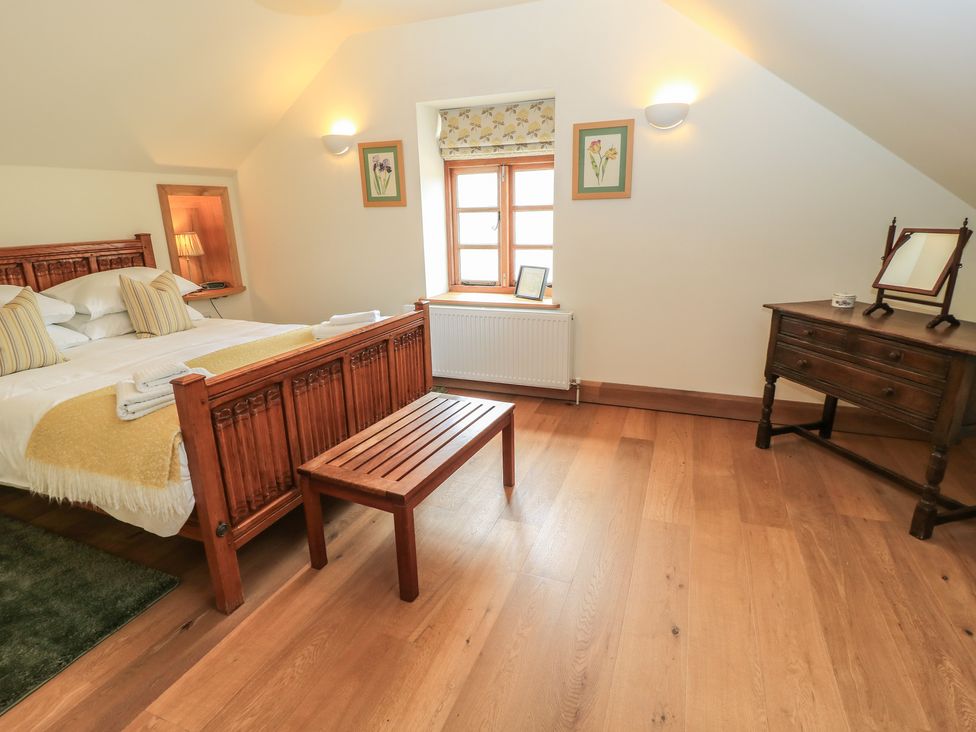 A bedroom with a bed and wooden furniture at Badger Cottage Babcary near Lydford-On-Fosse
