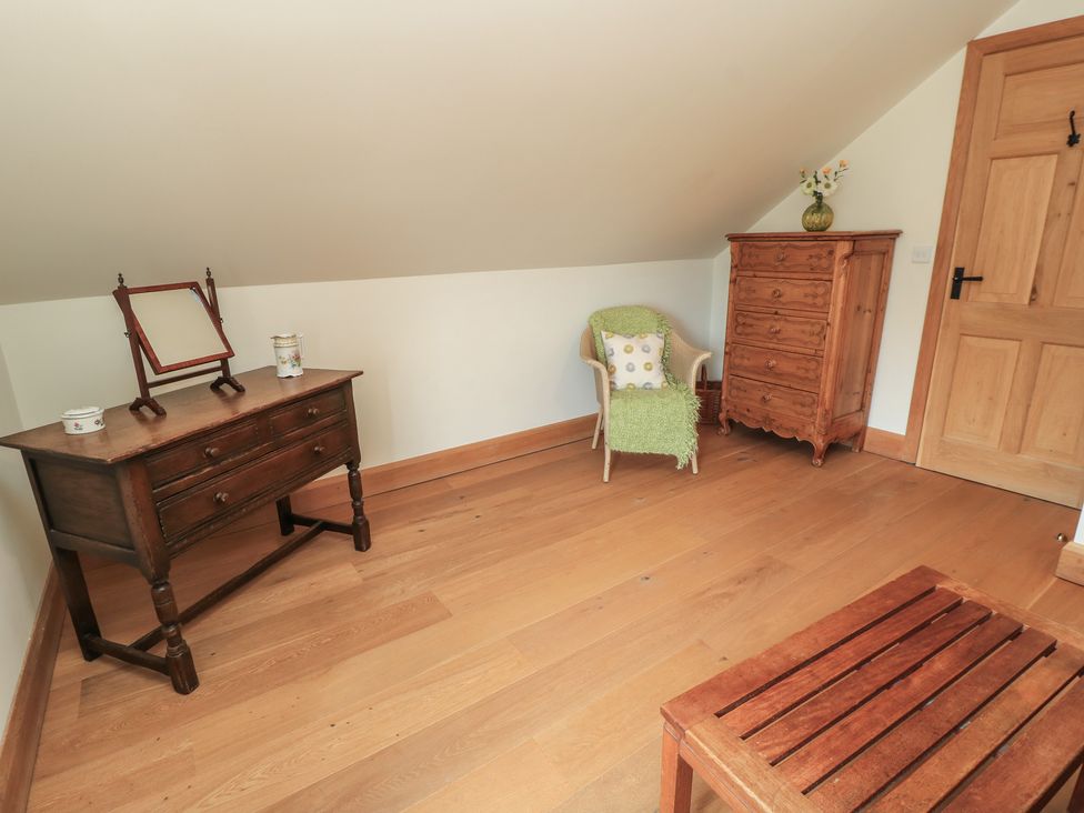 An attic room with a dresser and chest of drawers at Badger Cottage in Babcary near Lydford-On-Fosse