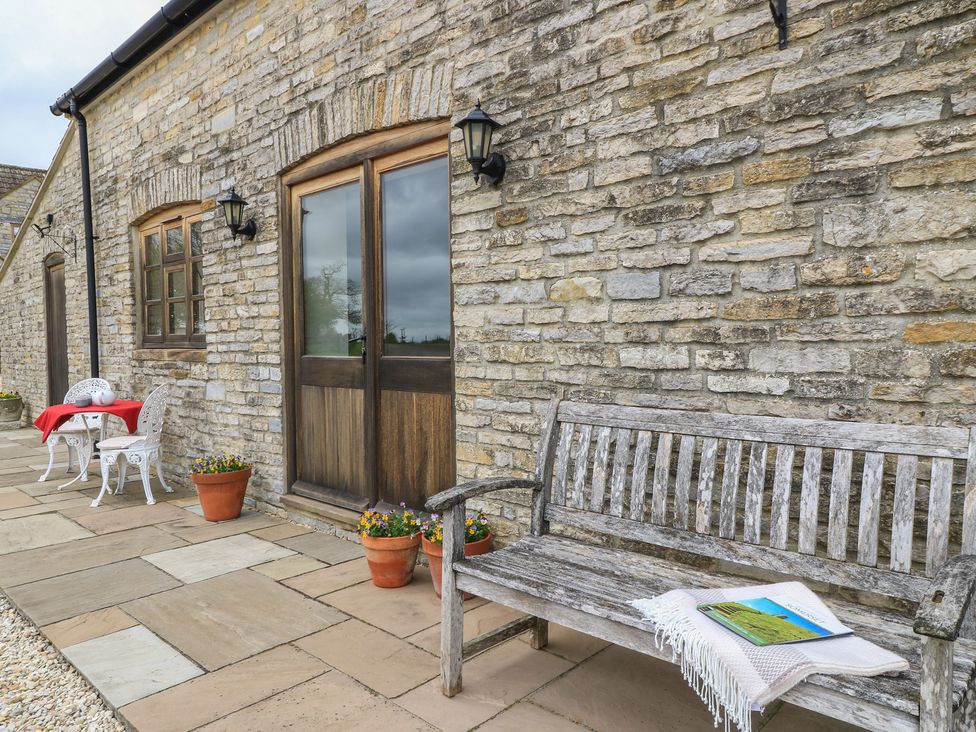 An outdoor seating area with a bench and table at Badger Cottage Babcary near Lydford-On-Fosse
