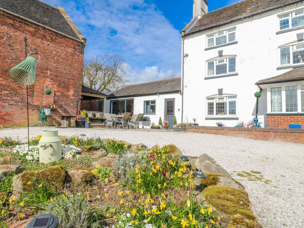 An outdoor area with seating and flowers at Fields Farm in Cheadle