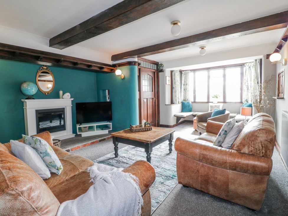A living room with sofas and a television at Fields Farm in Cheadle