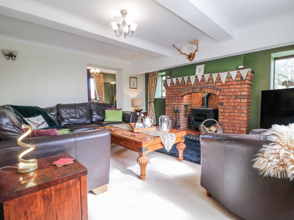 A living room with a fireplace and sofa at Fields Farm in Cheadle