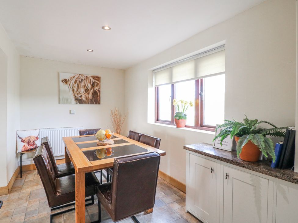 A dining room with a table and chairs at Fields Farm in Cheadle
