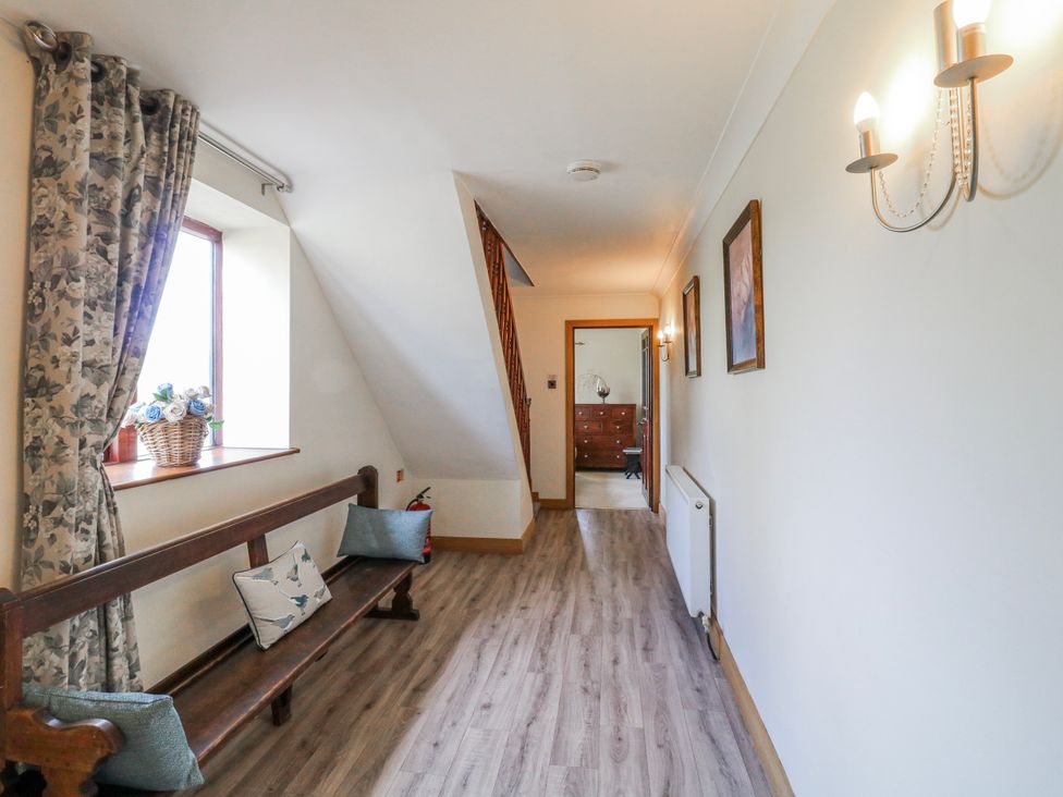 A hallway with a bench and window at Fields Farm in Cheadle