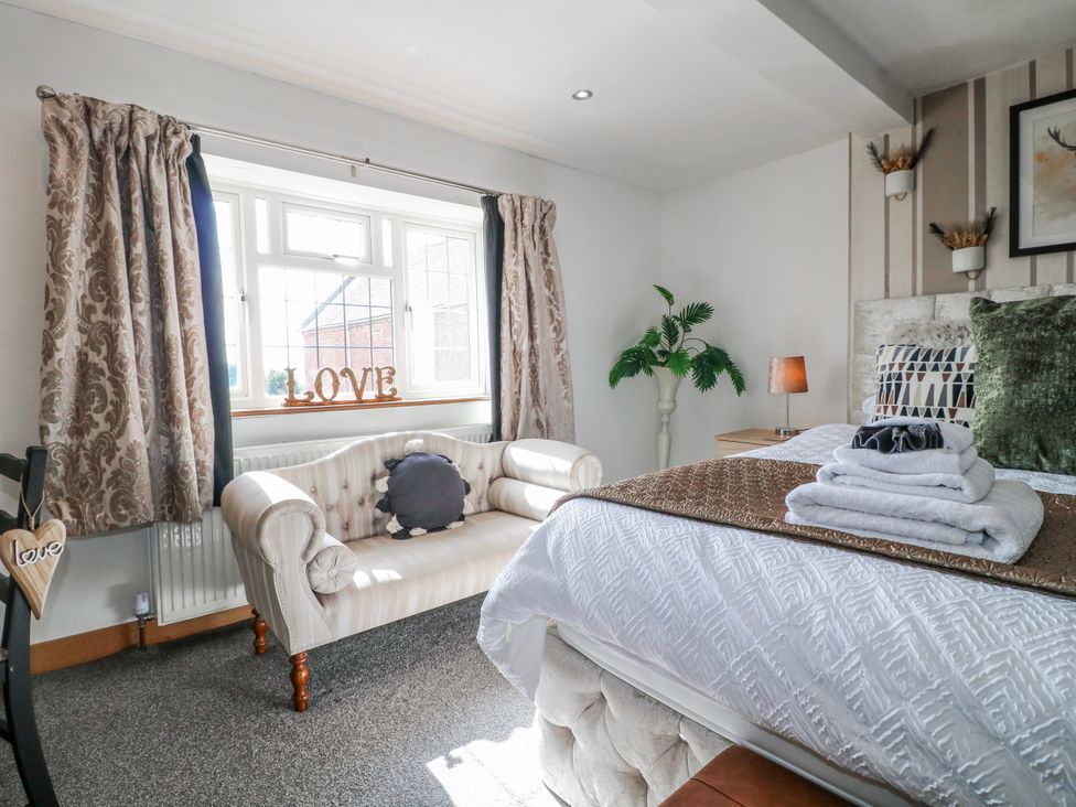 A bedroom with a bed and a couch at Fields Farm in Cheadle