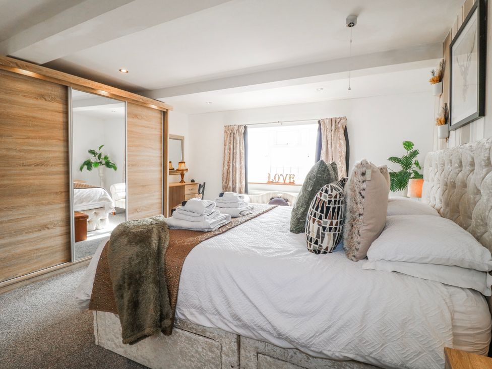 A bedroom with a bed and dressing area at Fields Farm in Cheadle