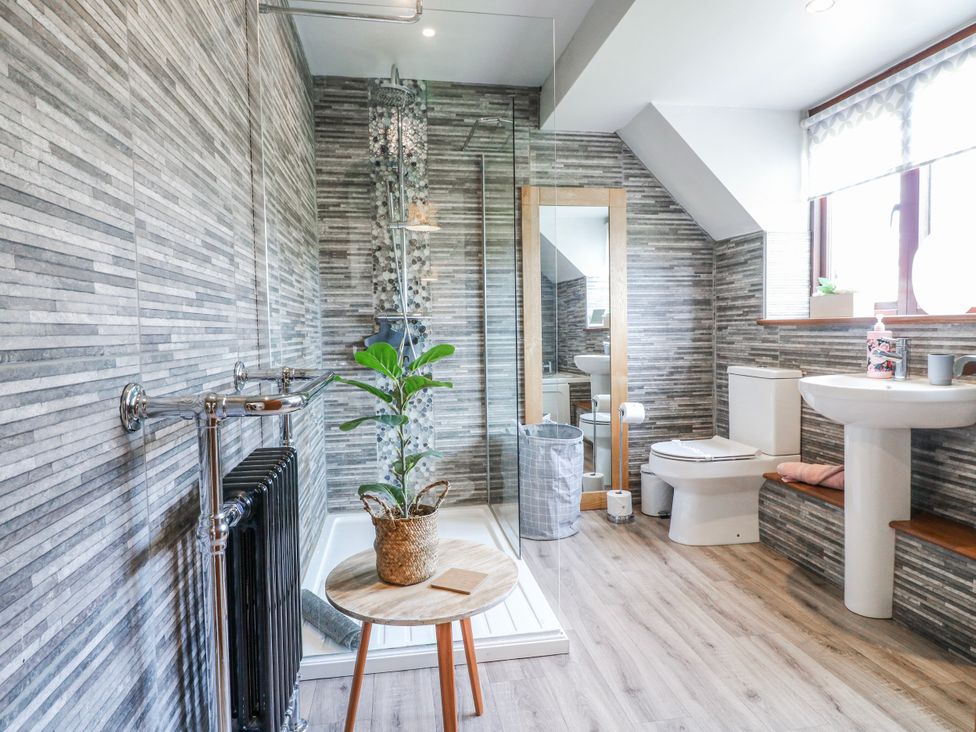 A bathroom with a shower, toilet, and sink at Fields Farm in Cheadle