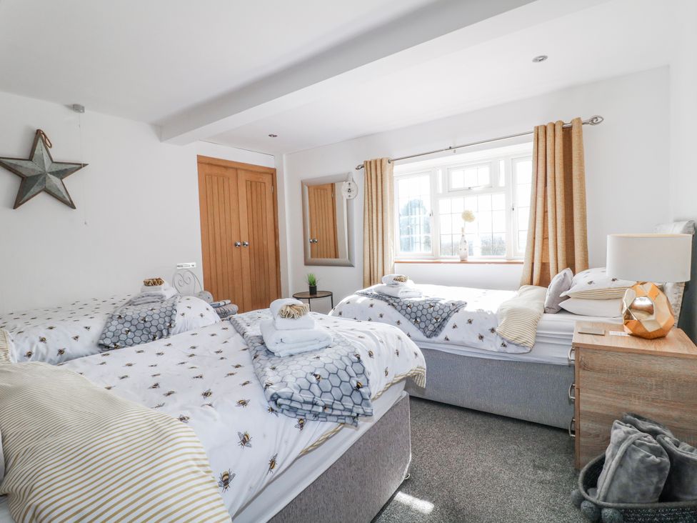 A bedroom with two beds and windows at Fields Farm Cheadle