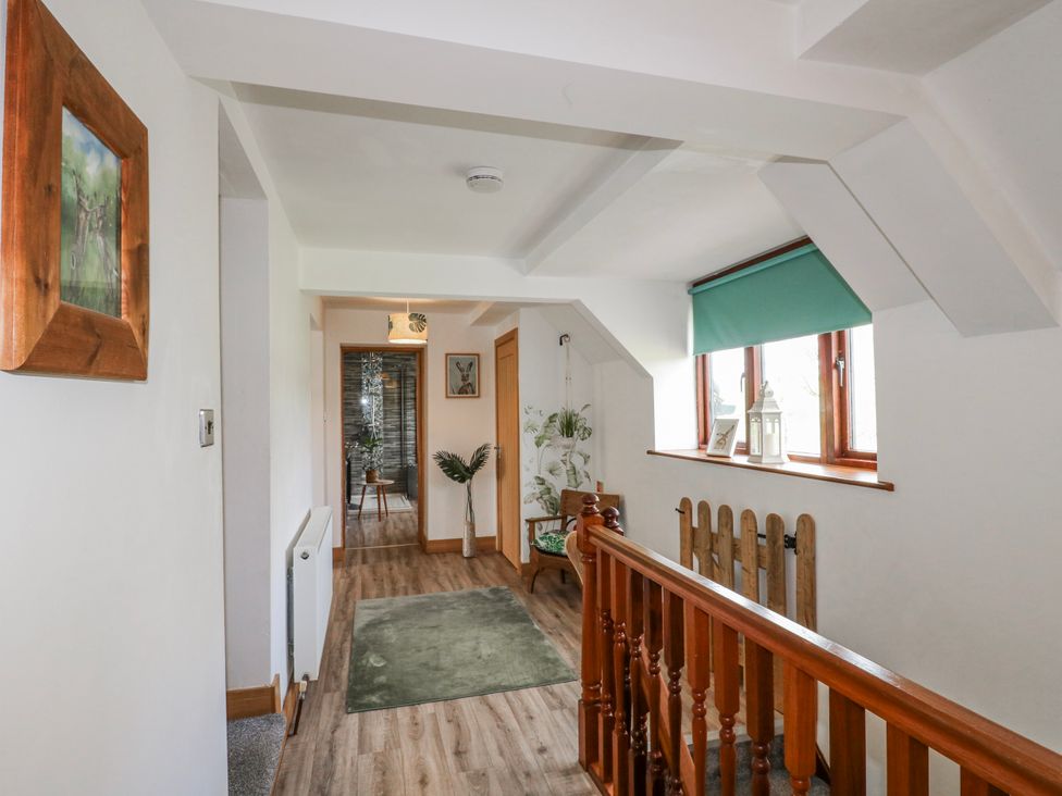 A hallway with stairs and a plant at Fields Farm in Cheadle
