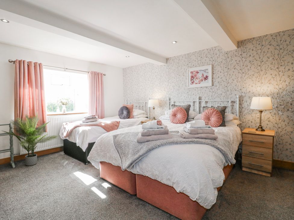 A bedroom with two beds and a window at Fields Farm in Cheadle