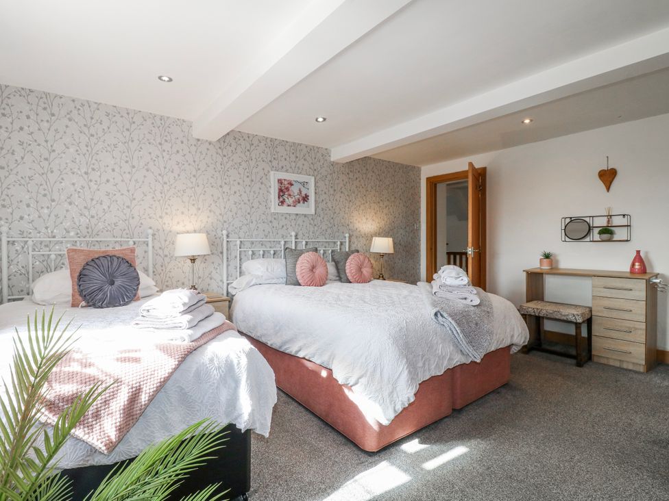 A bedroom with two beds and a desk at Fields Farm in Cheadle