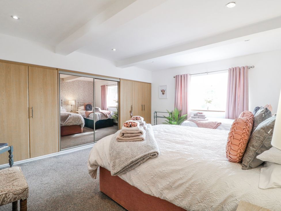 A bedroom with a bed and wardrobe at Fields Farm in Cheadle