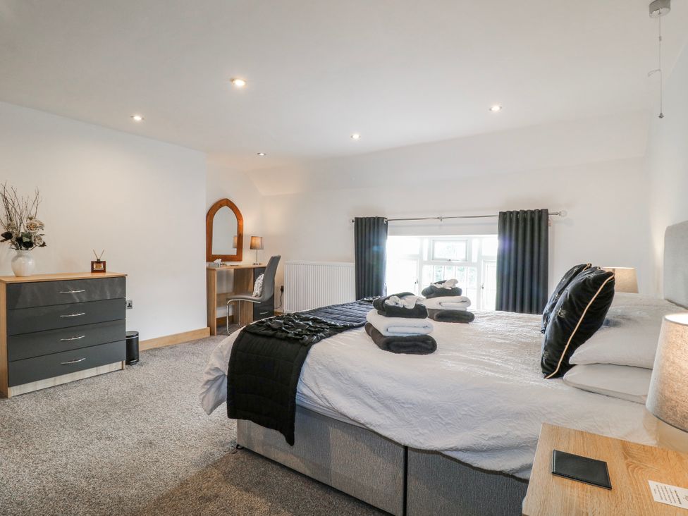 A bedroom with a bed and dresser at Fields Farm Cheadle