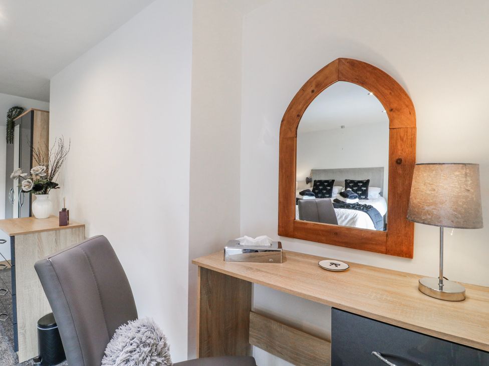 A bedroom with a desk and mirror at Fields Farm in Cheadle