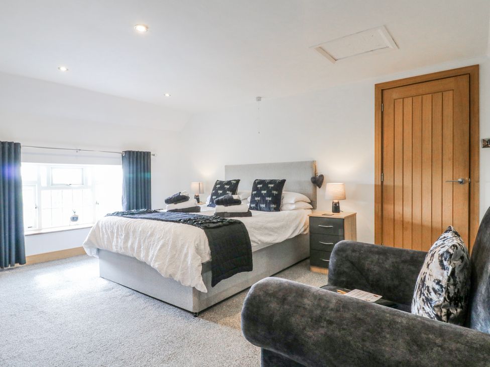 A bedroom with a bed and a sofa at Fields Farm in Cheadle