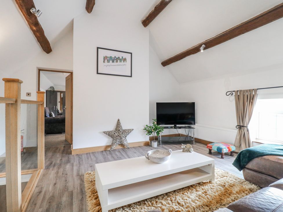 A living room with a television and a coffee table at Fields Farm in Cheadle
