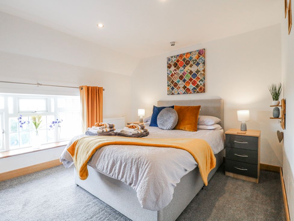 A bedroom with a bed and side table at Fields Farm in Cheadle