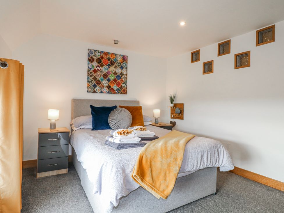 A bedroom with a bed and nightstand at Fields Farm in Cheadle
