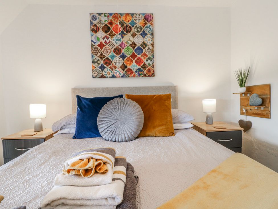 A bedroom with a bed and decorative pillows at Fields Farm in Cheadle