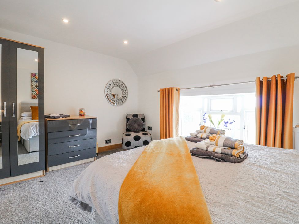 A bedroom with a bed, drawers, and a chair at Fields Farm in Cheadle