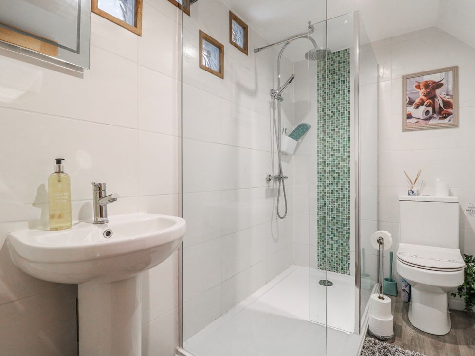 A bathroom with a shower, sink, and toilet at Fields Farm in Cheadle
