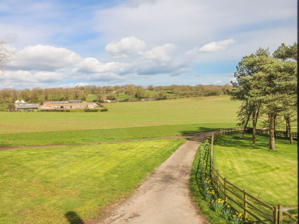 A landscape view with a dirt path and trees at Fields Farm in Cheadle