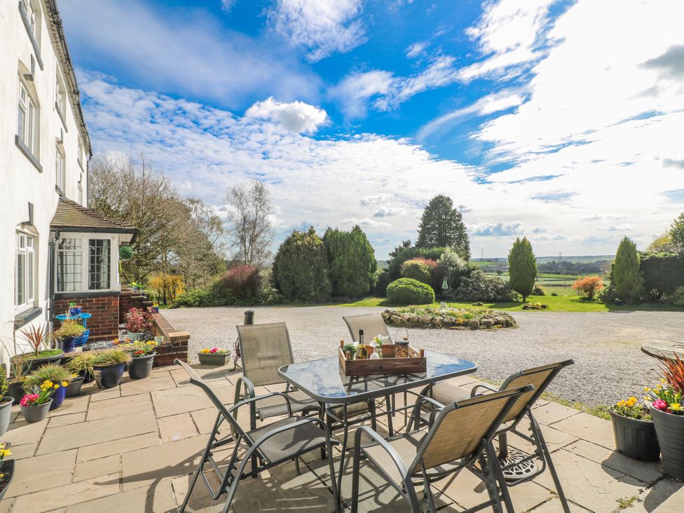A patio with a table and chairs at Fields Farm in Cheadle