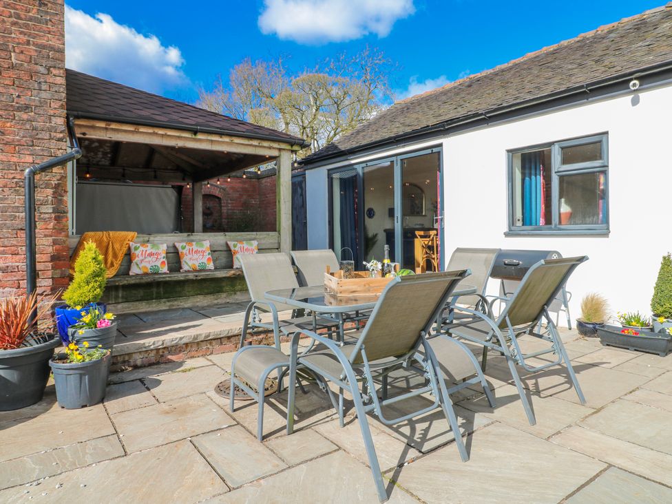 An outdoor seating area with a dining table and chairs at Fields Farm in Cheadle