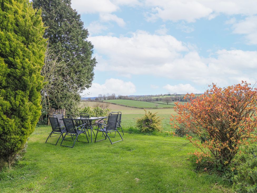 A garden with a table and chairs at Fields Farm in Cheadle