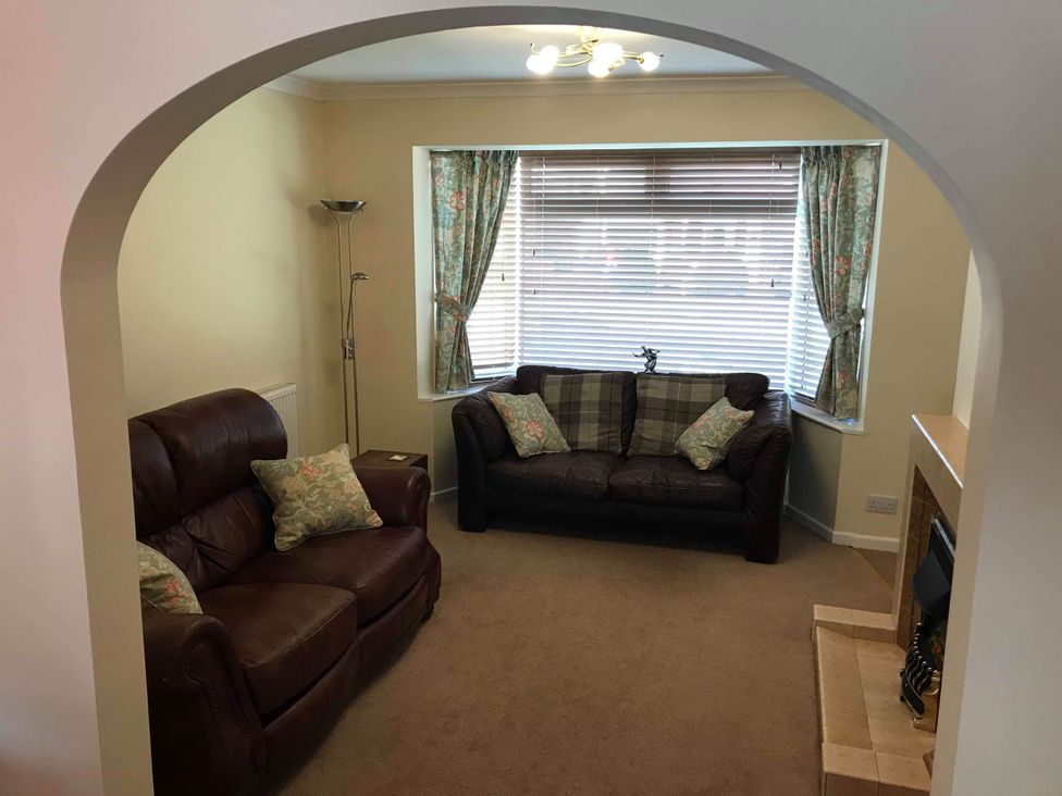 A living room with a sofa and armchair at Lavender Harmony House in Swindon