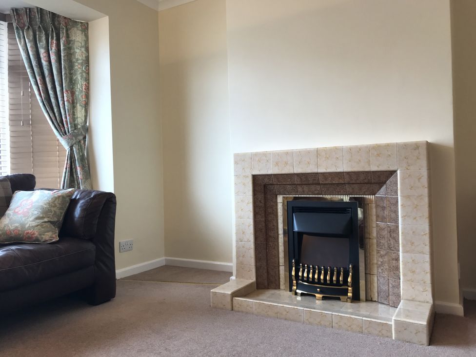 A living room with a fireplace and a sofa at Lavender Harmony House in Swindon