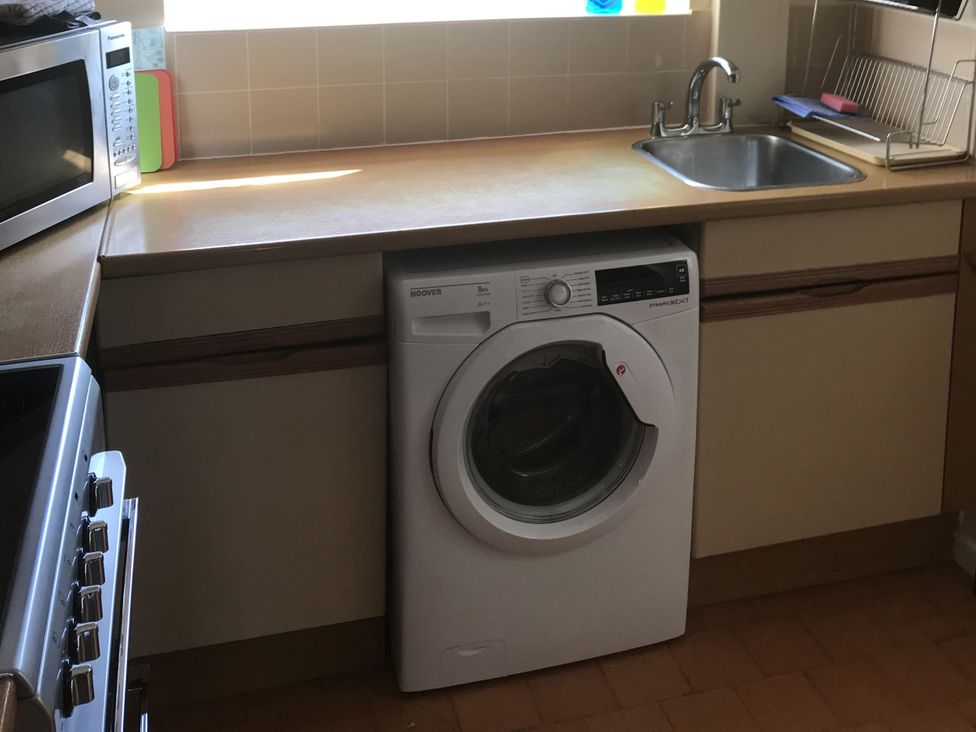 A kitchen with a washing machine and a sink at Lavender Harmony House in Swindon
